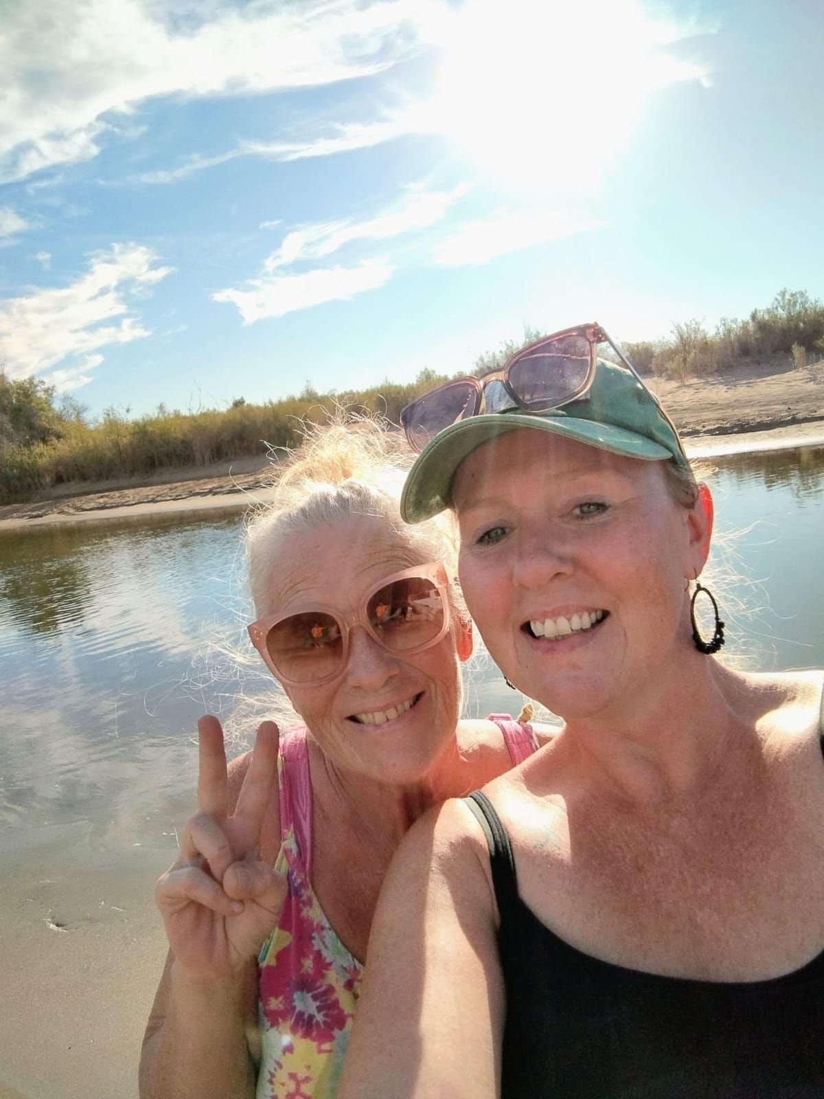 Two volunteers smiling together at the riverbank