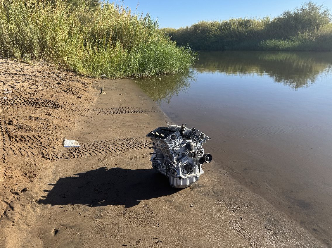 A discarded car engine block found on the riverbank